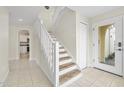 Welcoming entryway with staircase and tile floors leads to the kitchen area at 3076 Ocean Shore Blvd, Ormond Beach, FL 32176
