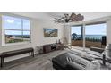 Bright living room with ocean views, modern ceiling fan, wood-look tile, and sliding glass doors to balcony at 3370 Ocean Shore Blvd # 205-B, Ormond Beach, FL 32176