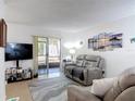 Comfortable living room with tile flooring, sliding glass doors to the outside, and coastal artwork at 420 Banana Cay Dr # A, South Daytona, FL 32119