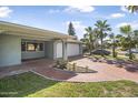 Paver driveway leading to a two-car garage, complemented by tropical landscaping at 44 Sandra Dr, Ormond Beach, FL 32176