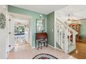 Inviting foyer with tile flooring and staircase, leading into the dining and living areas at 440 Champagne Cir, Port Orange, FL 32127