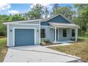 Charming single-story home featuring a front-facing garage and covered porch at 5620 Ridgewood Ave, De Leon Springs, FL 32130