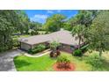 Charming single-story brick home with a well-manicured lawn, mature trees and a two car garage at 912 Fruitwood Pl, Port Orange, FL 32127