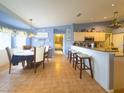 Open-concept kitchen and breakfast nook area with tiled flooring, breakfast bar, and view to next room at 10031 Sw 62Nd Cir, Ocala, FL 34476