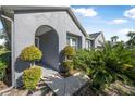 Home's covered arched entrance with lush tropical landscaping and decorative shrubbery at 117 Hagge Dr, Daytona Beach, FL 32124