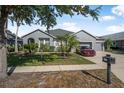 Beautiful gray single-story home with an attached three-car garage, a green lawn, and neatly trimmed landscaping at 117 Hagge Dr, Daytona Beach, FL 32124