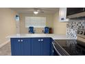 Kitchen featuring blue lower cabinets, quartz countertops and nautical themed hardware at 127 Mason Park Dr, Daytona Beach, FL 32117