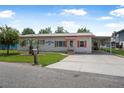 Charming white brick single-story home with a well-kept lawn and a convenient carport at 24538 Wildhog Rd, Astor, FL 32102