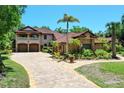 Two-story home boasts an elegant stone driveway, lush landscaping, and a three-car garage at 3513 Kilgallen Ct, Ormond Beach, FL 32174