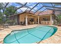 Sparkling pool surrounded by a screened enclosure with covered seating and an outdoor bar area at 3513 Kilgallen Ct, Ormond Beach, FL 32174
