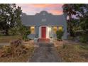 Charming single-story home featuring a stucco exterior, red door, and well-maintained landscaping at 509 Park Dr, Daytona Beach, FL 32114
