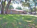 A one-story home with a nicely landscaped lawn and mature trees at 601 E Tall Pine Ter, Deland, FL 32724