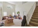 Spacious living room with high ceilings, staircase, and large windows providing natural light at 1305 Rebecca Dr, Haines City, FL 33844