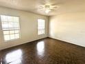 An empty bedroom with tile floors, two windows and a ceiling fan at 1355 Dexter E Dr, Port Orange, FL 32129