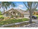Charming single-story home featuring well-kept landscaping and an attached two-car garage on a sunny day at 1956 Southern Dunes Blvd, Haines City, FL 33844
