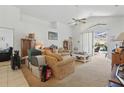 Bright living room with high ceilings, neutral carpet, sliding glass doors to the patio, and ceiling fan at 1956 Southern Dunes Blvd, Haines City, FL 33844