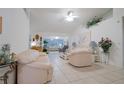 Inviting living room featuring high ceilings, neutral tile flooring, and comfortable seating arrangement at 4622 Secret River Trl, Port Orange, FL 32129