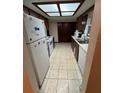 Kitchen with linoleum flooring, white appliances, and wood cabinetry at 9393 Sw 102Nd Pl, Ocala, FL 34481