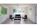 Bright living room featuring gray floors and wicker furniture providing views of the lush outdoors at 1301 Oakwood Ave, Daytona Beach, FL 32114
