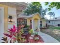 Inviting yellow home exterior with well-maintained landscaping, bench, and decorative house number at 1465 Admrial Nimitz Ave, Daytona Beach, FL 32124