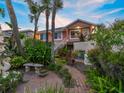 Charming two-story home with beautifully landscaped front yard, brick path, and stone bench at 1504 N Atlantic Ave, Daytona Beach, FL 32118