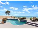 Inviting pool and jacuzzi with ocean view, surrounded by tile decking and lounge chairs at 1504 N Atlantic Ave, Daytona Beach, FL 32118