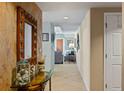 Inviting hallway with decorative mirror and table, neutral colors, and tiled flooring, with living space in the background at 2071 S Atlantic Ave # 1005, Daytona Beach Shores, FL 32118