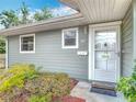 Close up of the house number, white trimmed windows, and front door of this light green single Gathering home at 244 Oakleigh Dr # 200, Deland, FL 32724