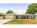 Charming brick ranch home features a well-maintained lawn, two-car garage, and inviting covered front porch at 2468 Scottville Ave, Deltona, FL 32725