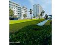 Well-maintained green lawn and walkways, and lush green landscaping around the condominium building at 2727 N Atlantic Ave # 602, Daytona Beach, FL 32118