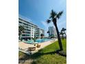 Beautiful, sparkling condominium swimming pool surrounded by tropical landscaping and resort building at 2727 N Atlantic Ave # 602, Daytona Beach, FL 32118