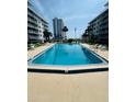 Clear, rectangular condominium swimming pool surrounded by lounge chairs and tropical landscaping at 2727 N Atlantic Ave # 602, Daytona Beach, FL 32118