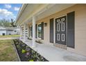 Inviting home exterior featuring a quaint front porch and blooming flower beds at 290 Greenwood Cir, Ormond Beach, FL 32174