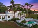 Stately home exterior showcasing a pool, manicured lawn, and a staircase leading to a patio at 37918 N County Road 44A, Eustis, FL 32736