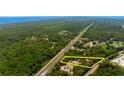 Aerial view of a property surrounded by trees, near a main road, with yellow highlighted border at 486 S Us Highway 1, Oak Hill, FL 32759