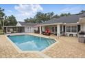 Sparkling pool area with a covered patio, outdoor seating, and brick pavers at 5865 Ross Creek Rd, Lakeland, FL 33810