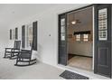 Cozy covered porch with rocking chairs, offering a glimpse into the living room at 5865 Ross Creek Rd, Lakeland, FL 33810