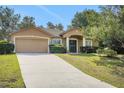 Charming home with a two-car garage, well-maintained lawn, and inviting front entrance with decorative columns at 881 Westline Ave, Deltona, FL 32725