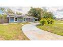 Landscaped front yard leading to a cozy home with a driveway, solar panels, and a welcoming pathway at 991 Dawson Dr, Deltona, FL 32725