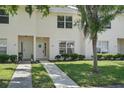 Charming townhome with a manicured lawn, lush shrubbery, and a quaint walkway leading to the front door at 1502 Deer Springs Rd, Port Orange, FL 32129