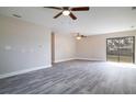 Spacious living room with hardwood floors, two fans, and a sliding door leading to the backyard at 1744 Valencia Ave, Ormond Beach, FL 32174