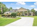 Stunning home with a long driveway, well-manicured lawn, and beautiful landscaping at 1766 Roscoe Turner Trl, Port Orange, FL 32128