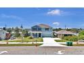 A two-story home with blue siding, a well-maintained lawn and a long driveway with landscaping at 3828 S Atlantic Ave, Daytona Beach, FL 32118