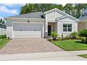 Charming single-story home with a well-manicured lawn, brick driveway, and attached two-car garage at 5539 Estero Loop, Port Orange, FL 32128