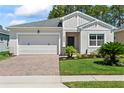 Charming single-story home with a well-manicured lawn, brick driveway, and attached two-car garage at 5539 Estero Loop, Port Orange, FL 32128