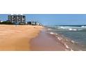Scenic view of the sandy beach and gentle waves, ideal for relaxation and beachside activities at 1239 Ocean Shore Blvd # 11D, Ormond Beach, FL 32176