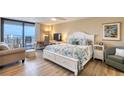 Serene bedroom featuring light wood floors, a comfortable bed, and a balcony with ocean views at 1239 Ocean Shore Blvd # 11D, Ormond Beach, FL 32176