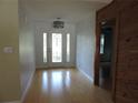 Bright foyer featuring a decorative glass front door and sidelights, with hardwood flooring throughout at 543 Sandy Oaks Blvd, Ormond Beach, FL 32174