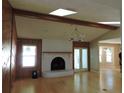 Inviting living room featuring a brick fireplace, beamed ceiling, and hardwood floors at 543 Sandy Oaks Blvd, Ormond Beach, FL 32174