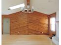 Bright living room boasts wood paneled walls, hardwood floors, and a modern chandelier at 543 Sandy Oaks Blvd, Ormond Beach, FL 32174